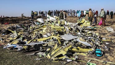 People stand near collected debris at the crash site of Ethiopia Airlines near Bishoftu on March 11, 2019. (AFP)