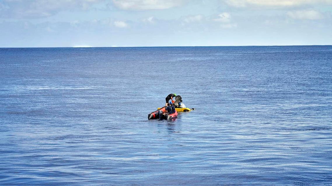 A small boat carrying Stephanie Marie, a young scientist from the Seychelles, reaches a submersible for a technical test dive near the tiny Alphonse atoll. (AFP)