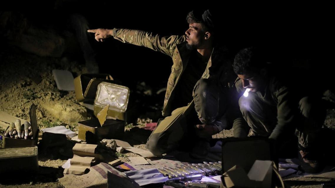 A fighter of Syrian Democratic Forces (SDF) gestures as he sits near ammunition in the village of Baghouz, Deir Al Zor province, Syria, on March 11, 2019. (Reuters)