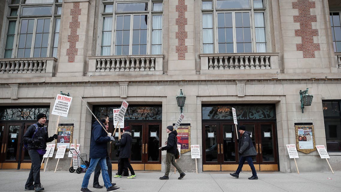 Members of the renowned Chicago Symphony Orchestra carry signs as they strike on March 11, 2019 in Chicago, after 11 months of pay talks failed to reach an agreement. The musicians say the company is asking them to reduce overall salary and benefits despite increasing revenue from sales and donations.