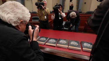Members of the media gather around copies of volume 1 of President Donald Trump’s new budget for 2020 that has been delivered to the House Budget Committee in Washington, DC. (AFP)