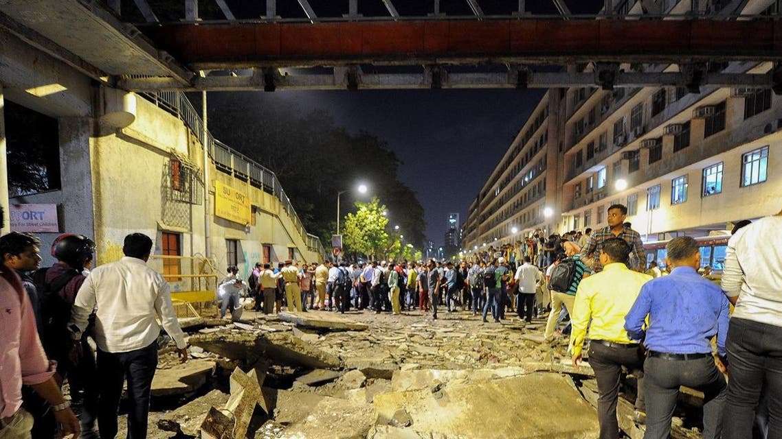 Onlookers and office goers gather around rubbles of a footbridge outside the Chattrapati Shivaji Maharaj Terminus railway complex in Mumbai on March 14, 2019. (AFP)