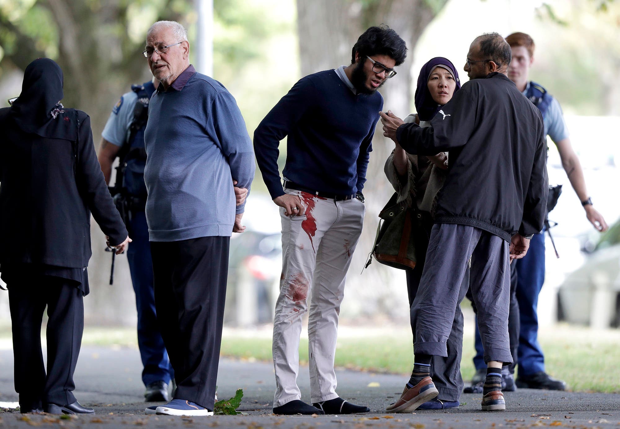 People stand across the road from a mosque in central Christchurch on March 15, 2019. (AP)
