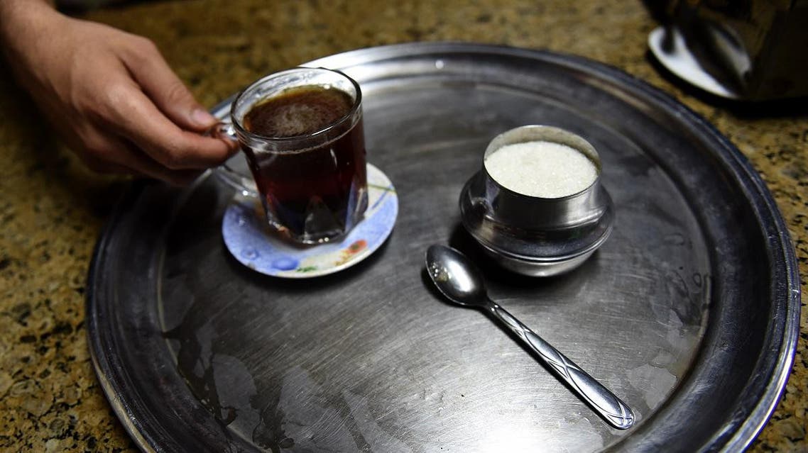 An Egyptian man serves a cup of tea with sugar at a cafe in the capital Cairo. (Reuters)