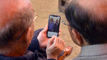 Relatives look the pictures of Pakistani citizen Naeem Rashid, and his son Talha Naeem, who were reportedly killed in the Christchurch mosque shooting. (AP)