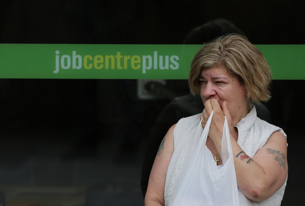A woman stands by the entrance to a job center in east London.