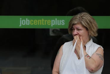 A woman stands by the entrance to a job center in east London (File photo).