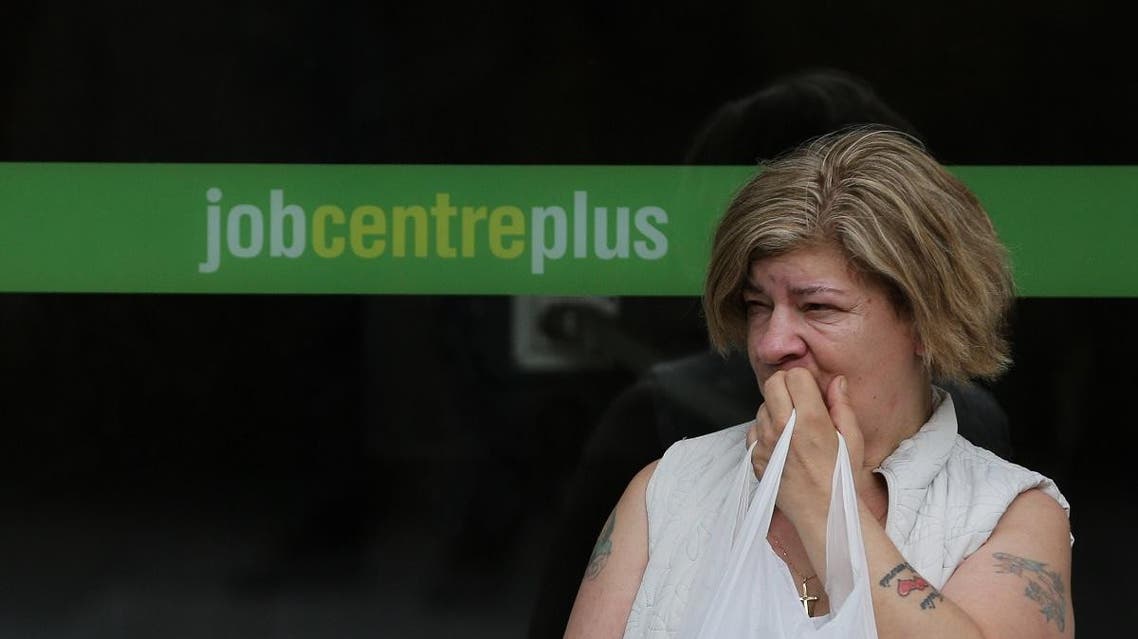 A woman stands by the entrance to a job center in east London on July 20, 2016.