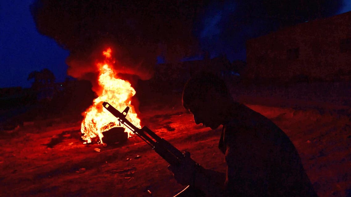 An SDF fighter in front of a bonfire near the village of Baghouz in the countryside of Syrian province of Deir Ezzor on March 20, 2019. (AFP)