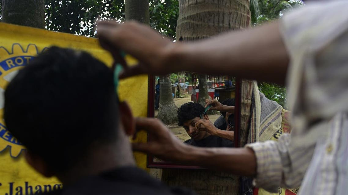 A Bangladeshi barber attends to a customer at his roadside stall in Dhaka. (AFP)