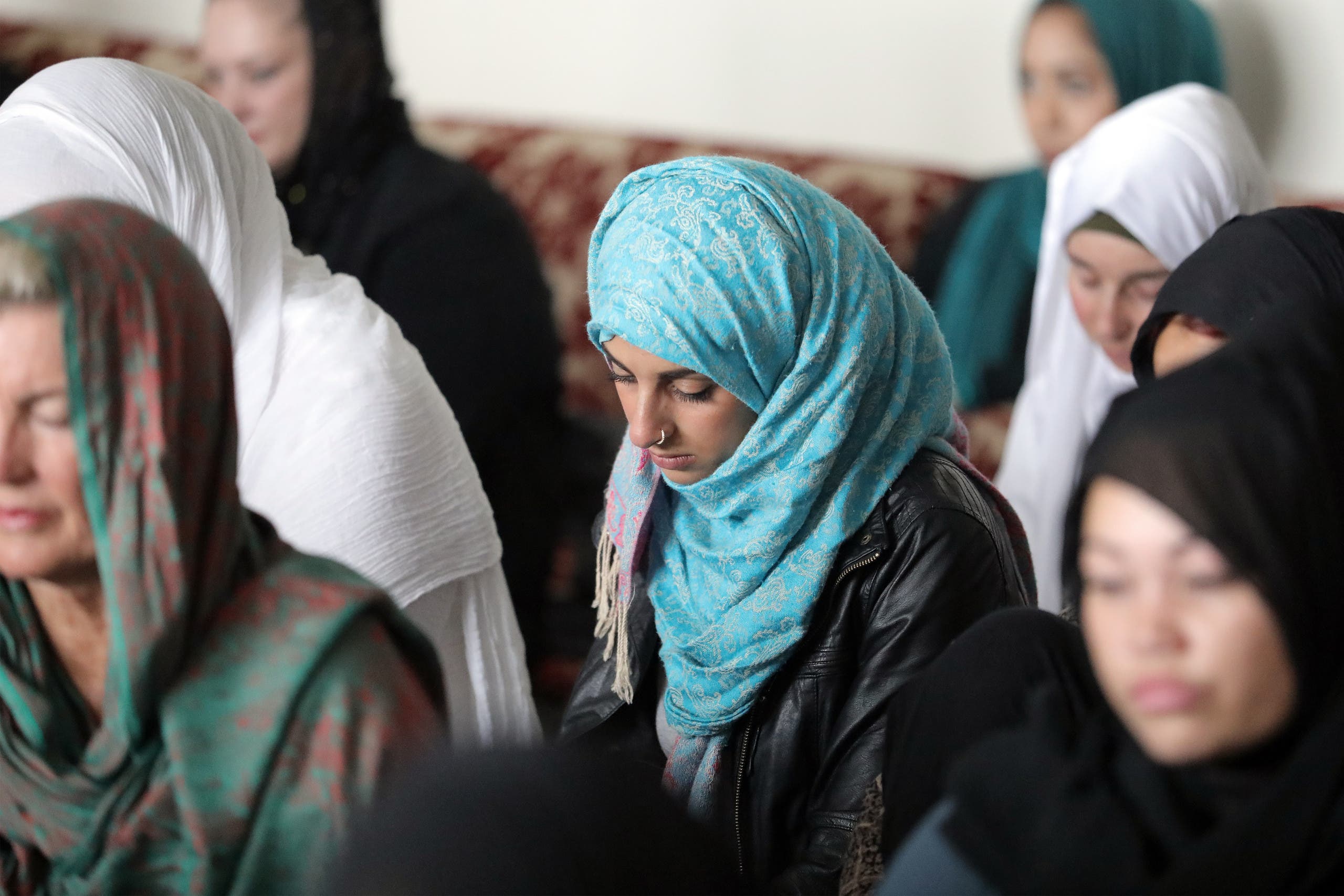 Local residents with head scarfs gather for the call to prayer and the moment of silence at Masjid Umar mosque (AFP)
