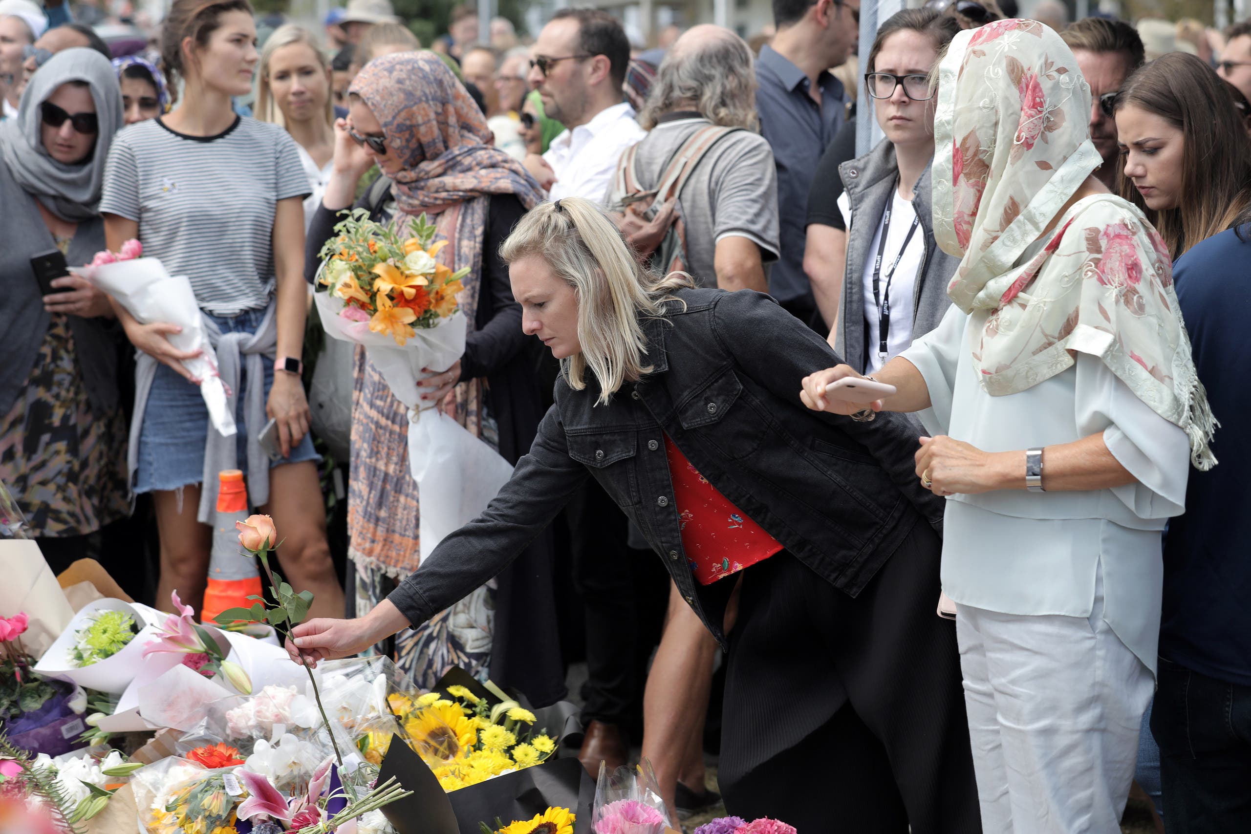 Local residents with head scarfs gather for the call to prayer and the moment of silence at Masjid Umar mosque (AFP)