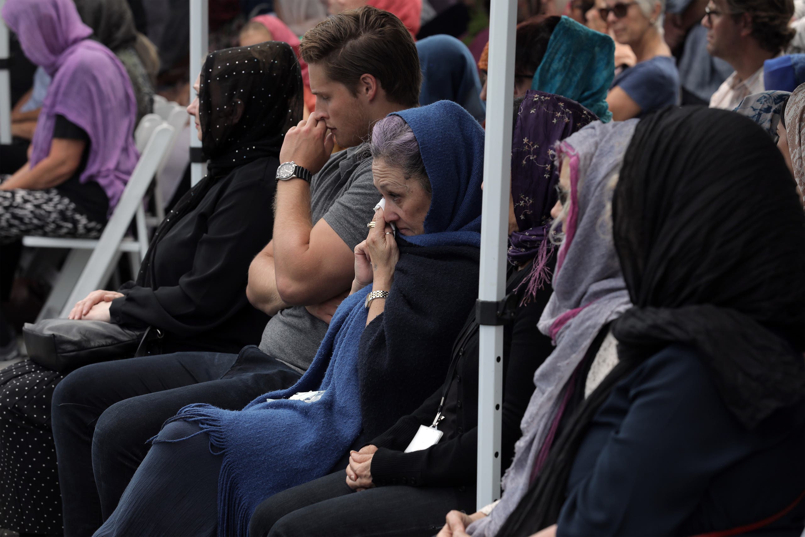 Local residents with head scarfs gather for the call to prayer and the moment of silence at Masjid Umar mosque (AFP)