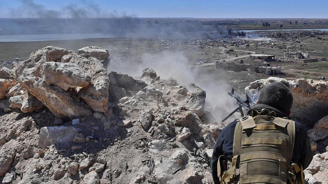 A fighter with the Syrian Democratic Forces (SDF) opens fire toward a part of Baghouz where remaining Islamic State (IS) group fighters are holding out in their last position, in the countryside of the eastern Syrian province of Deir Ezzor on March 18, 2019. (AFP)