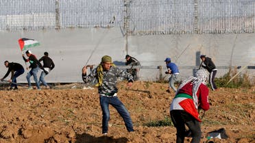 Palestinian protesters use slingshots to hurl objects during clashes with Israeli forces across the fence east of Gaza City on March 22, 2019. (AFP)