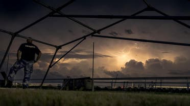 In this handout photo from the Commonwealth of Australia, Department of Defence taken on March 23, 2019 shows lightning in the skies surrounding Katherine Showgrounds as Australian Army soldiers from The 5th Battalion, Royal Australian Regiment and Royal Australian Air Force Base Tindal personnel set up emergency shelter tents for residents in anticipation of Tropical Cyclone Trevor. A severe category 3 cyclone blew into the key mining region of Pilbara in Western Australia on March 24, 2019, forcing evacuations and a halt to port operations, as the north of the country dealt with the effects of Cyclone Trevor, as the powerful category 4, weakened to a tropical storm overnight as it moved inland in the sparsely populated region. CPL TRISTAN KENNEDY / Commonwealth of Australia, Depar / AFP