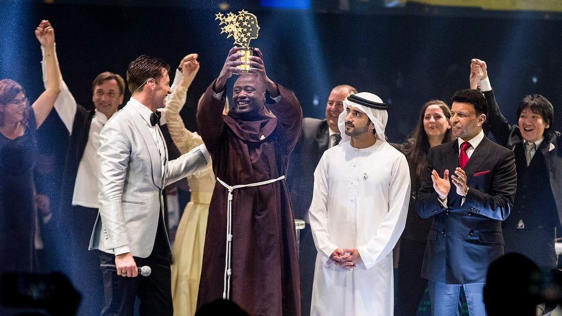 Kenyan teacher Peter Tabichi (C) holding up the Global Teacher Prize (GTP) trophy after winning the US$ 1 million award during an official ceremony in Dubai. (AFP)
