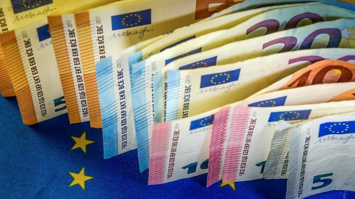 Euro banknotes are displayed next to a European Union flag. (AFP)