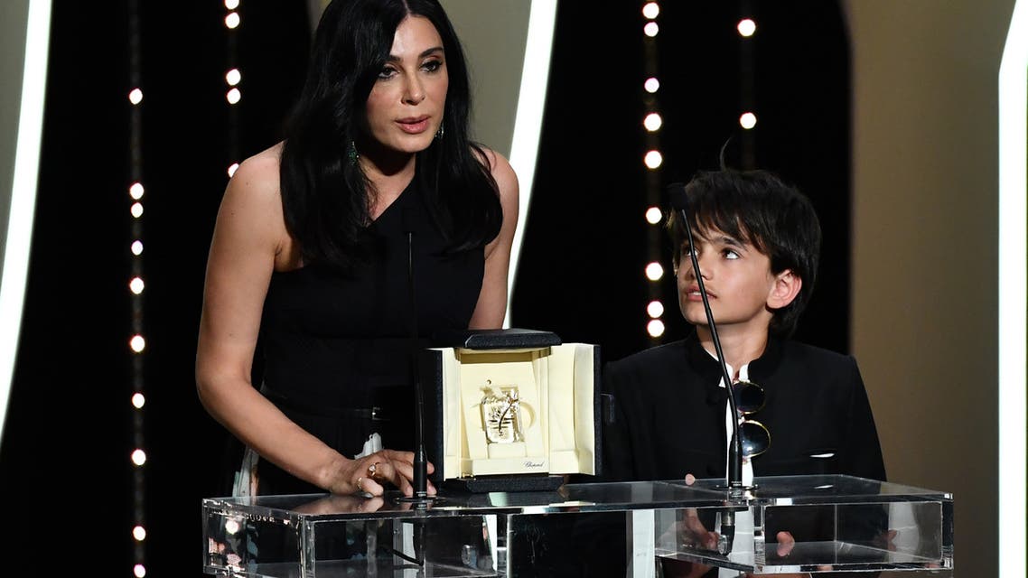 Lebanese director and actress Nadine Labaki (L) delivers a speech on stage next to Syrian actor Zain al-Rafeea after she was awarded with the Jury Prize for the film Capharnaum on May 19, 2018 during the closing ceremony of the 71st edition of the Cannes Film Festival in Cannes, southern France. Alberto PIZZOLI / AFP