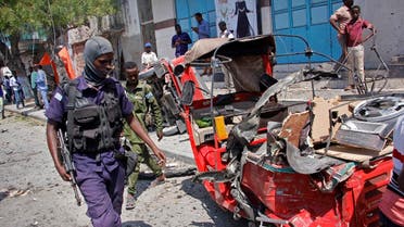 A policeman walks past a destroyed vehicle after an attack using an explosives-laden vehicle on a restaurant in Mogadishu, Somalia Thursday, March 28, 2019. (AP)