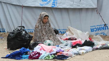 A displaced girl sells second-hand items in the souk or market of al-Hol camp for displaced people in northeastern Syria. (AFP)