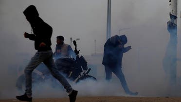 Palestinians react to tear gas fired by Israeli troops during a protest at the Israeli-Gaza border fence, on March 29, 2019. (Reuters)