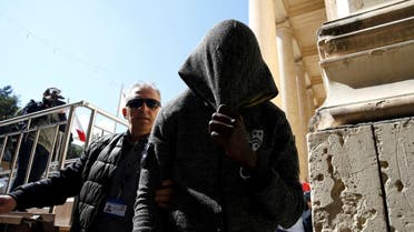 One of the migrants charged with hijacking the merchant ship Elhiblu 1 is escorted by a police officer out of the Courts of Justice in Valletta. (Reuters)