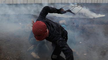 A Palestinian demonstrator runs for cover during a protest marking Land Day and the first anniversary of a surge of border protests. (Reuters)