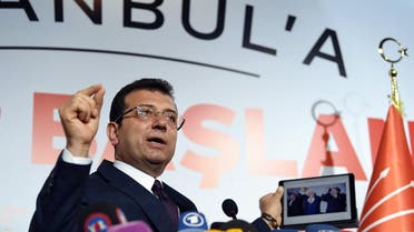 Ekrem Imamoglu, who claimed victory as Istanbul mayor, shows a picture of the 1994 local election featuring Istanbul Metropolitan municipality Refah Party (RP) candidate Recep Tayyip Erdogan (R), conservative Refah Party (RP) leader Necmettin Erbakan (C) and his opponent Social Democratic Populist Party (SHP) Nurettin Sozen, on his tablet during a press conference. (AFP)