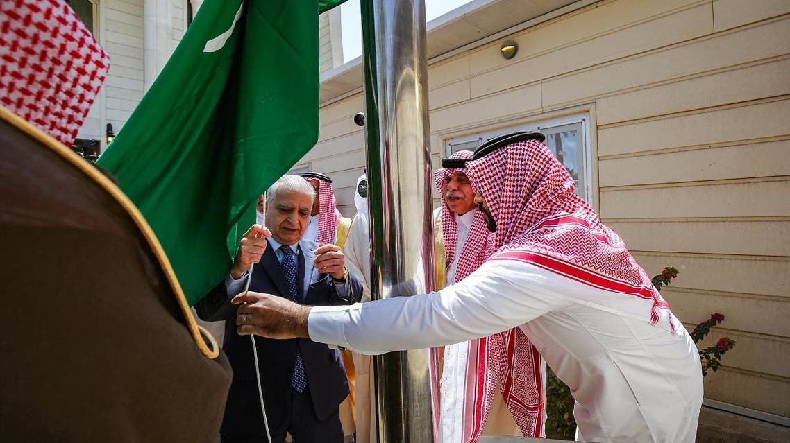 Iraqi Foreign Minister Mohammad Ali al-Hakim (C-L) raises the Saudi flag alongside Saudi Arabia's Trade and Investment Minister Dr. Majid Al-Qasabi (2nd-R) during the inauguration of the new Saudi consulate compound in Baghdad on April 4, 2019. (AFP)