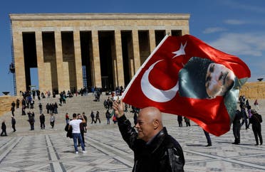 أحد الأتراك يلوح بالعلم التركي وعليه صورة مصطفى كمال أتاتورك في أنقرة