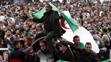 A man carries a national flag during a protest against the appointment of interim president, Abdelkader Bensalah. (Reuters)