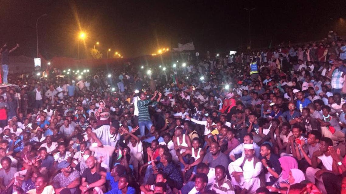 Sudanese demonstrators chant slogans as they gather at night during a demonstration in front of the military headquarters in Khartoum on April 10, 2019. (AFP)