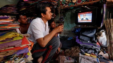 Men watch Narendra Modi on a TV screen inside their shop in Kolkata on March 27, 2019. (Reuters)
