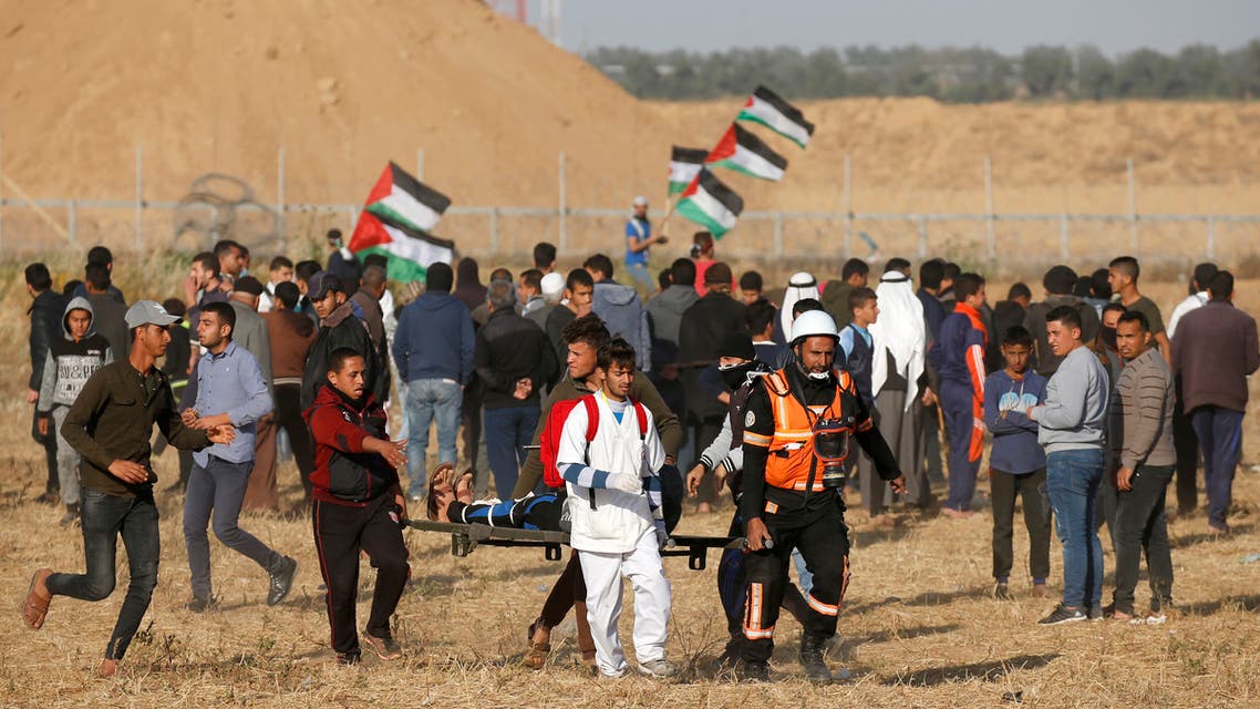 Palestinian paramedics carry an injured protester during a demonstration near the border between Israel and Khan Yunis in the southern Gaza Strip, on April 12, 2019.