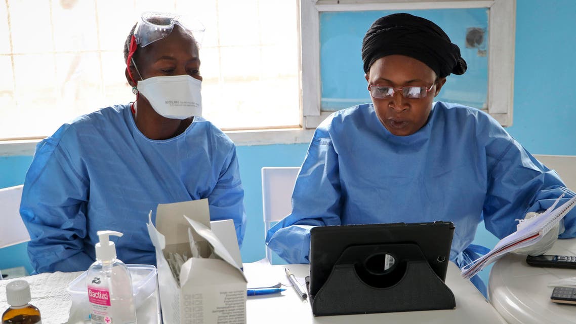 two World Health Organization aid workers prepare to vaccinate other health workers from the DRC, who will be on the front lines of the Ebola outbreak vaccinating people suspected of being infected with the disease, in Mbandaka, Congo. (AP)