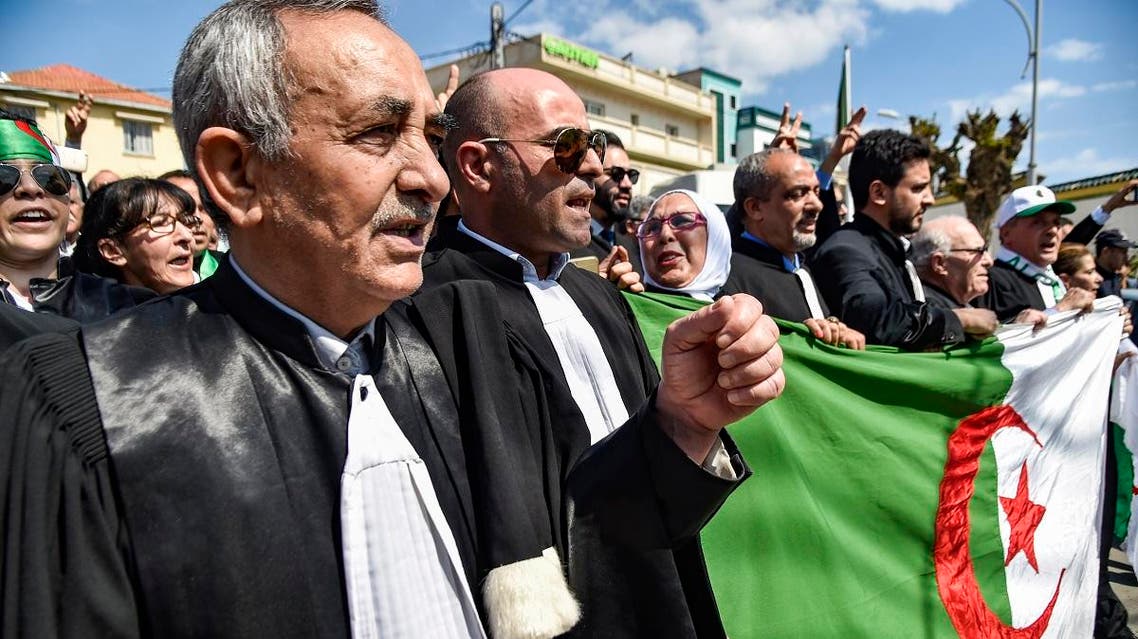 Algerian lawyers and judges chant slogans and raise a national flag as they gather for a demonstration for the independence of the judiciary outside the Justice Ministry headquarters in the capital Algiers. (AFP)