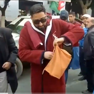 بالفيديو.. لماذا ارتدى هذا الشخص برنس الحمام وحمل شامبو وسط مظاهرات الجزائر؟ 