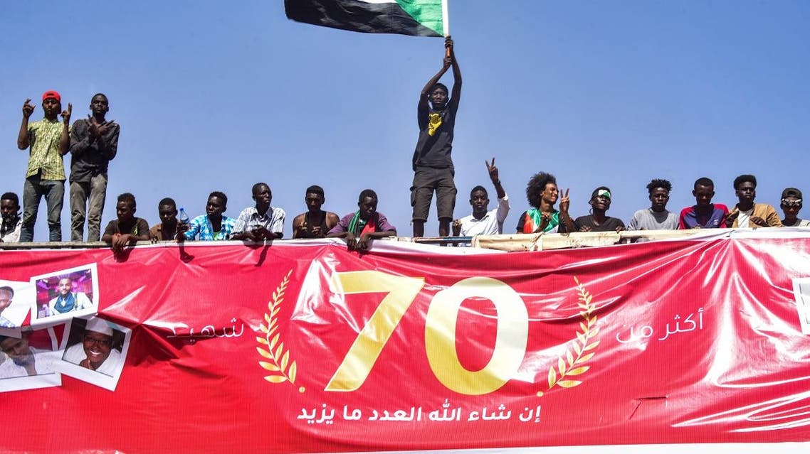 A Sudanese demonstrator waves a national flag during a rally demanding a civilian body to lead the transition to democracy, outside the army headquarters in the Sudanese capital Khartoum on April 13, 2019. (AFP)