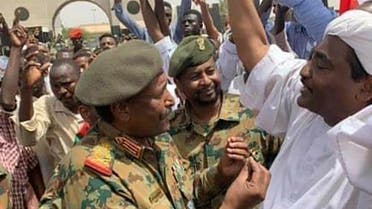 A photo of Lieutenant General Abdel Fattah al-Burhan, the new chief of the military council, went viral on social media, as he speaks with opposition figures demonstrating against Omar al-Bashir’s regime, on April 12, 2019. (AFP)