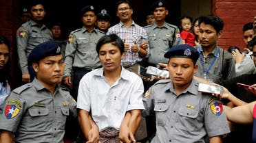 Detained Reuters journalist Kyaw Soe Oo and Wa Lone are escorted by police as they leave after a court hearing in Yangon,Myanmar, on August 20, 2018. (Reuters)