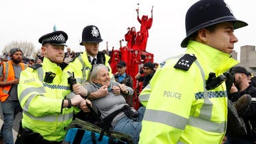 Police officers detain a climate change activist at Waterloo Bridge during the Extinction Rebellion protest in London on April 16, 2019. (Reuters)