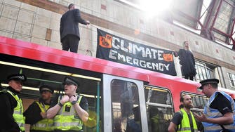Climate change protesters climb on train at London’s Canary Wharf