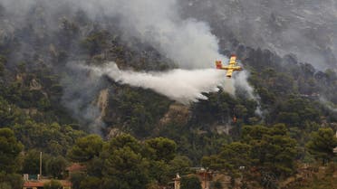 A fire-fighting plane drops water above a forest as a fire broke out at the French-Italian border in Menton, on September 9, 2015. (File photo: AFP)