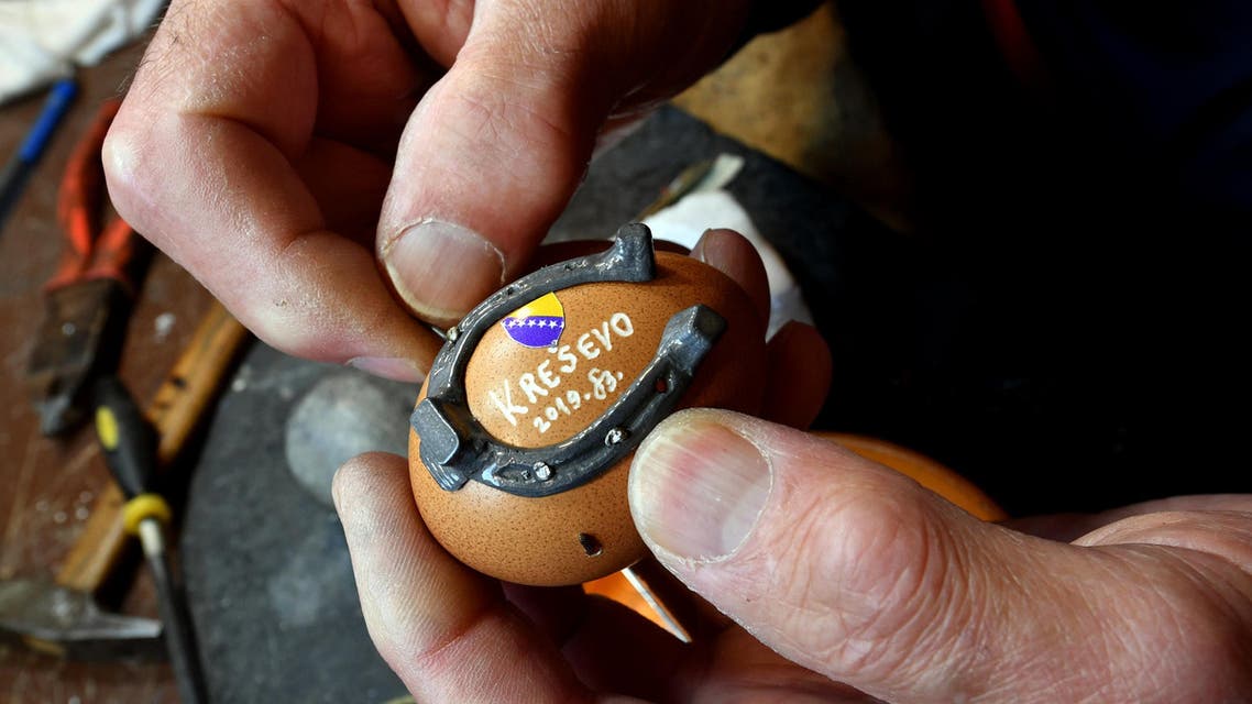 Stjepan Biletic, 71, handcrafts man from Central-Bosnian town of Kresevo, nails miniature horseshoe onto an egg, in his workshop, on April 17, 2019. (AFP)