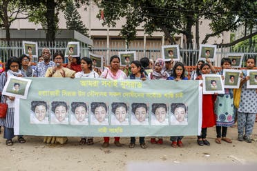 In this photo taken on April 12, 2019 Bangladeshi women hold placards and photographs of schoolgirl Nusrat Jahan Rafi at a protest in Dhaka, following her murder by being set on fire after she had reported a sexual assault. (AFP)