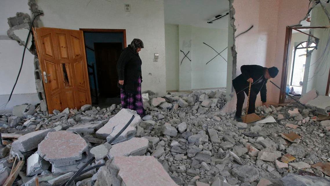 The parents of Arafat Irfaiya, a 29-year-old Palestinian- stands inside the damaged family home after Israeli army buldoser destroyed it in the Israeli-occupied West Bank town of Hebron, on April 19, 2019. (AFP)