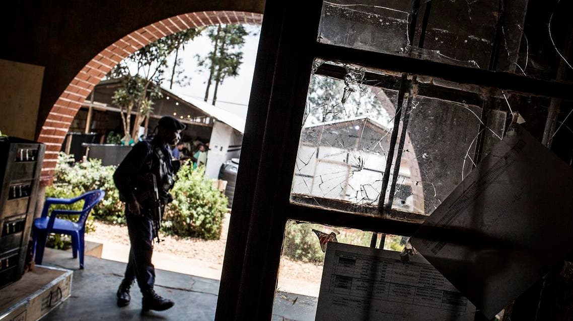 A Police officer stands guard next to a window riddled with bullet holes in an Ebola treatment centre, which was attacked in the early hours of the morning on March 9, 2019 in Butembo.