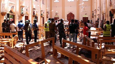 Sri Lankan security personnel walk through debris following an explosion in St Sebastian's Church in Negombo, north of the capital Colombo, on April 21, 2019. (AFP)