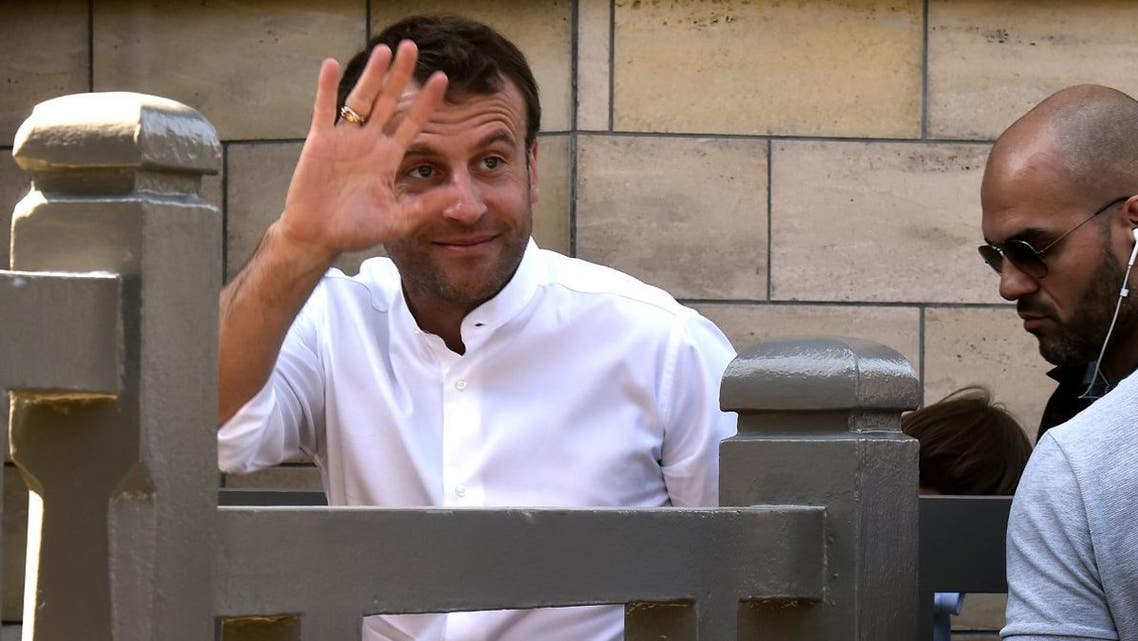 French President Emmanuel Macron (L) waves as he gets home in Le Touquet in northern France on April 21, 2019, where he is staying for the Easter weekend.